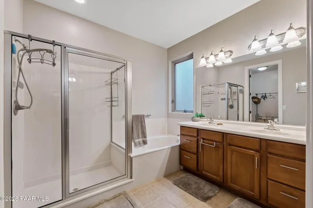 a bathroom with a double vanity sink mirror and shower