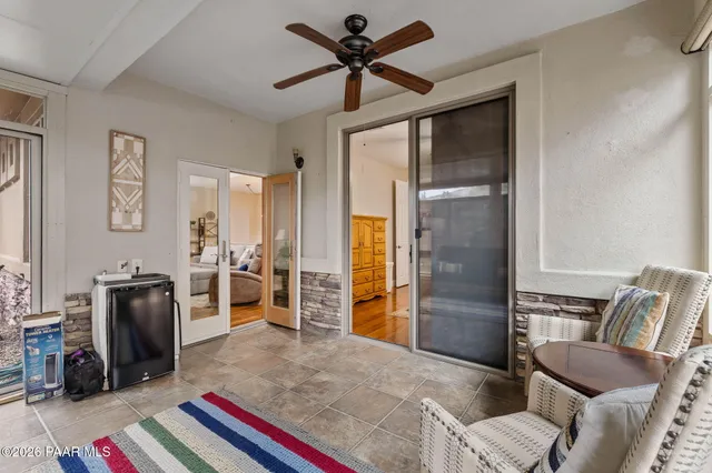 a living room with furniture a flat screen tv and a refrigerator