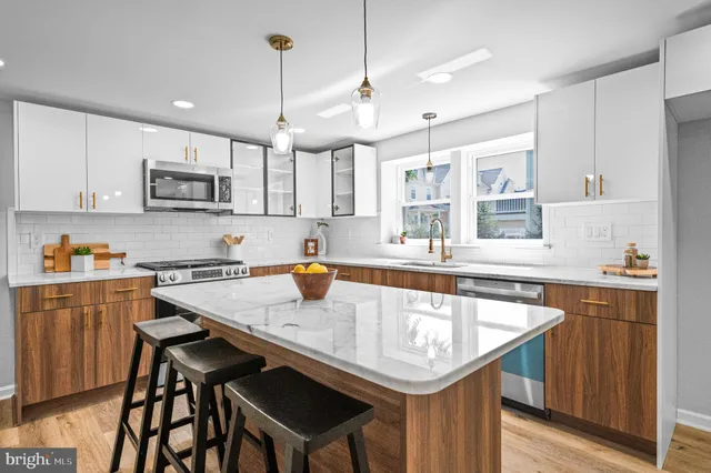 a kitchen with granite countertop a sink a counter space cabinets and stainless steel appliances