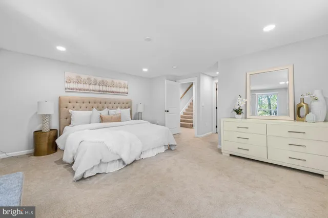 a bedroom with a white bed and dresser