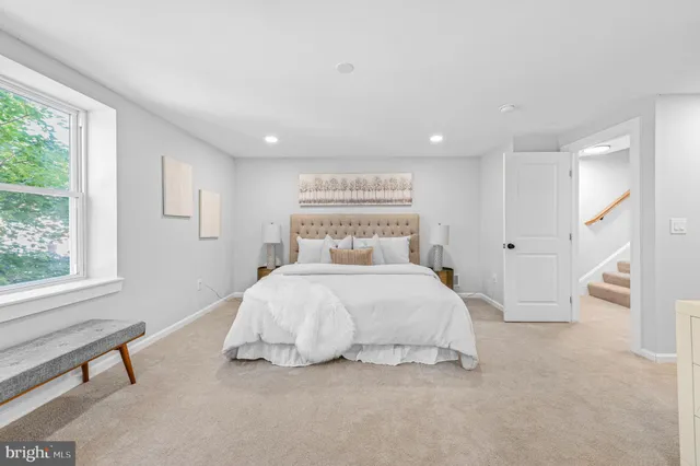 a bedroom with a bed and a large window