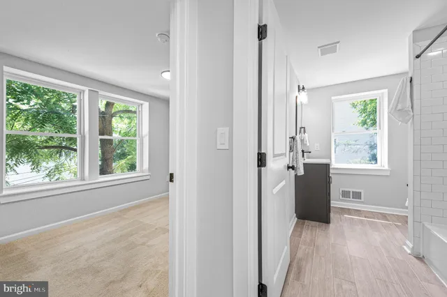 a view of hallway with a sink wooden floor and windows