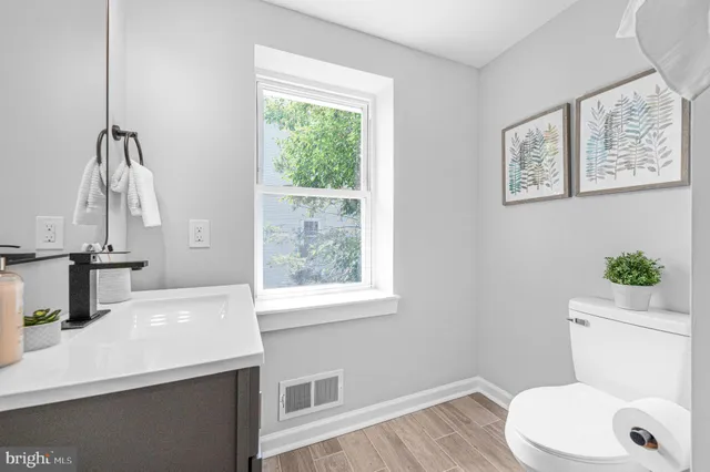 a bathroom with a sink a toilet and a window