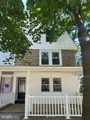 a front view of a house with a tree