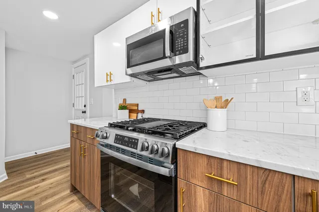 a kitchen with stainless steel appliances granite countertop a stove and a microwave
