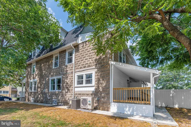 a front view of a house with a tree