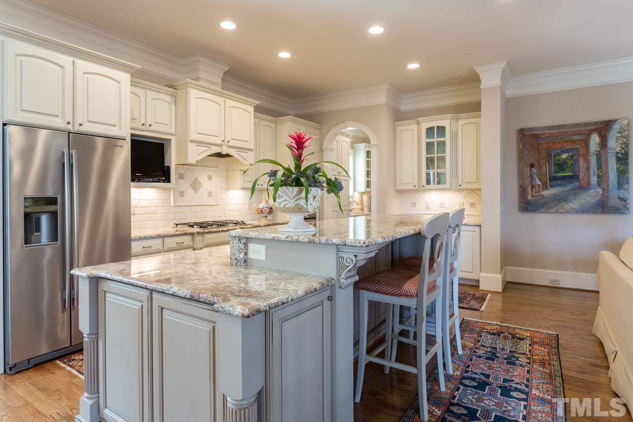2308 Beechridge Road Raleigh, NC 27608 - Photo 15 of 27 a kitchen with stainless steel appliances granite countertop a kitchen island a stove a sink cabinets and a dining table