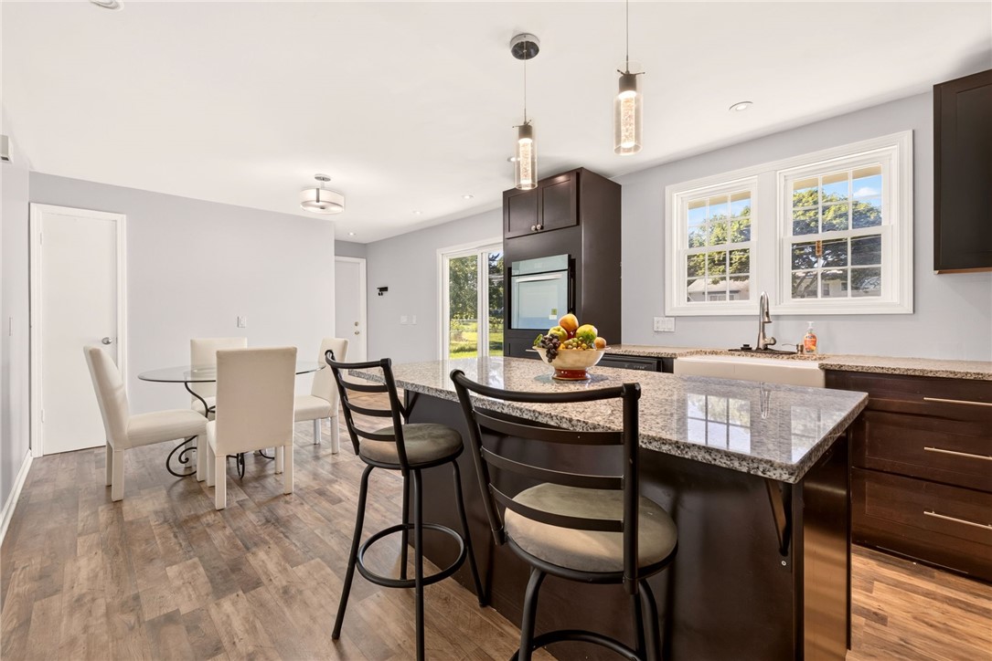 44 Friel Road Henrietta, NY 14623 - Photo 8 of 24 A kitchen island with a granite top and stools provides an excellent central hub for meal prep and casual dining