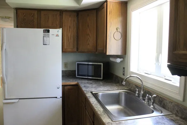 a close view of a sink and a refrigerator in a kitchen