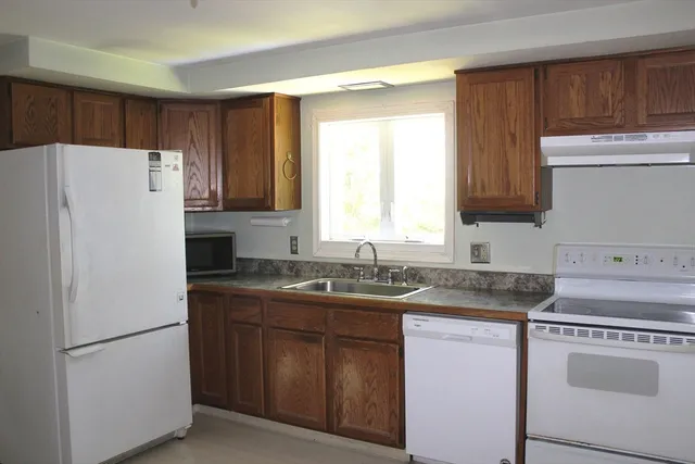 a kitchen with a refrigerator sink stove and cabinets