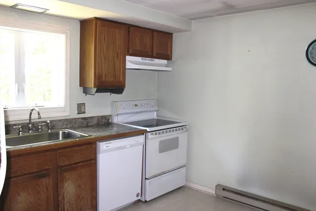 an empty room with a fireplace and windows