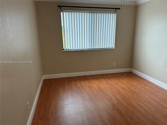 an empty room with wooden floor and a window