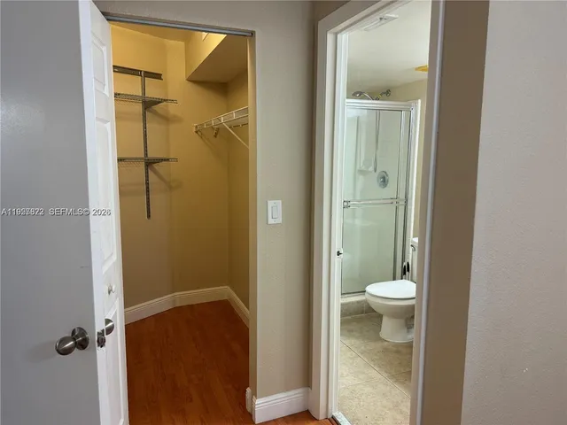 a bathroom with a granite countertop shower a toilet and a sink