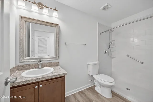 a bathroom with a granite countertop sink toilet and shower