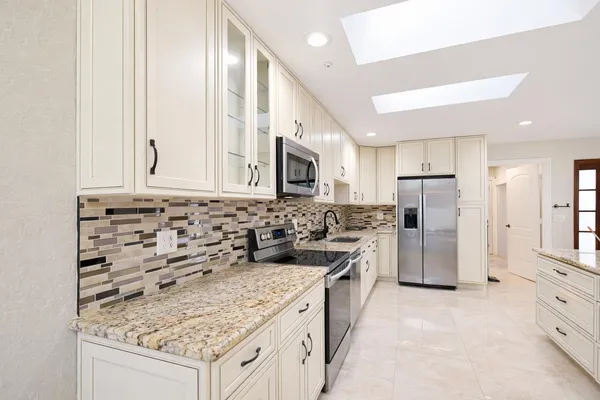 a kitchen with stainless steel appliances granite countertop a sink stove and refrigerator