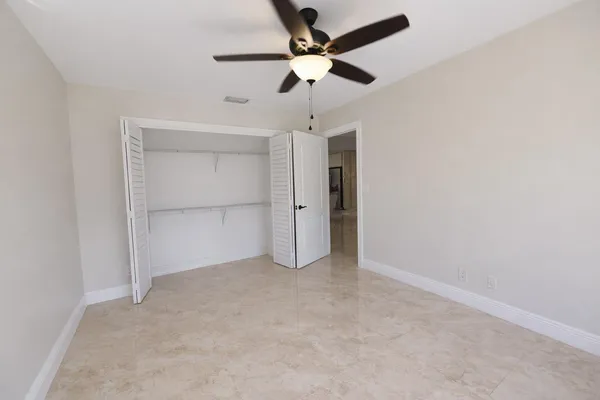 an empty room with chandelier fan