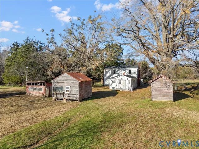 a front view of a house with a yard and large tree