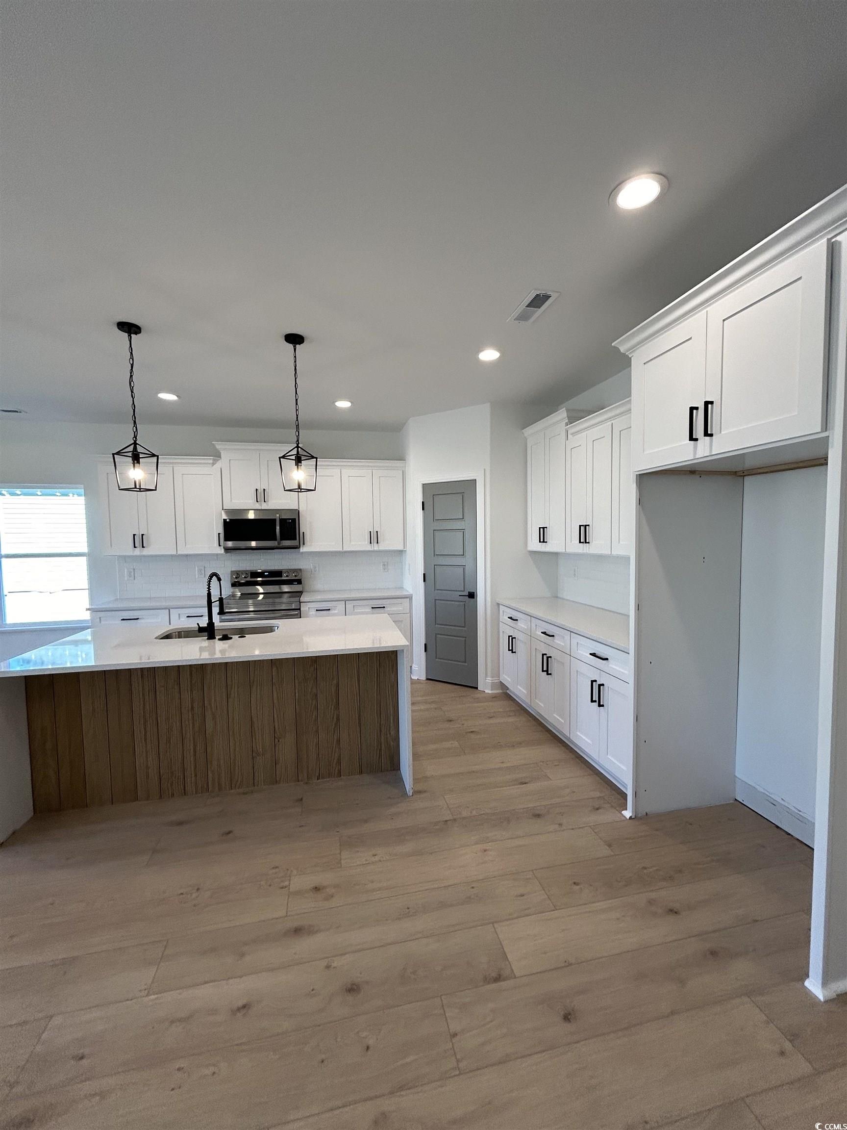 518 War Eagle Court Longs, SC 29568 - Photo 10 of 23 Kitchen featuring pendant lighting, white cabinetr