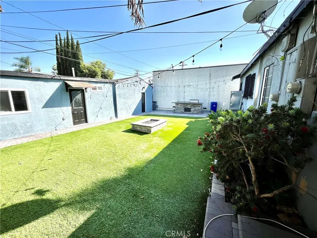 a view of a backyard with table and chairs potted plants