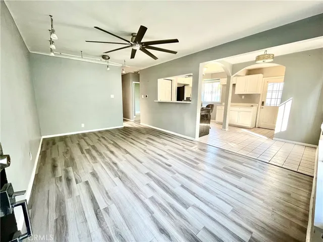 a view of a livingroom with wooden floor and a ceiling fan