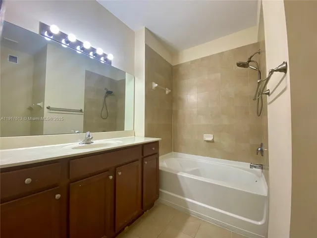 a bathroom with a tub a sink shower and mirror