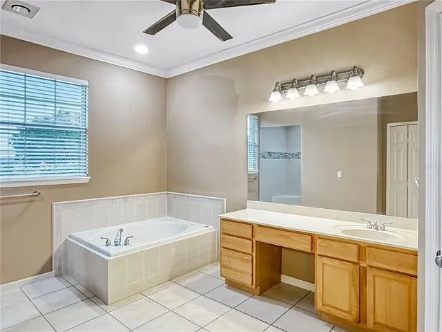 a bathroom with a tub a sink and a chandelier