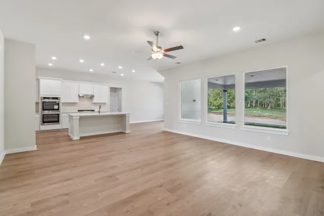 an empty room with wooden floor and window