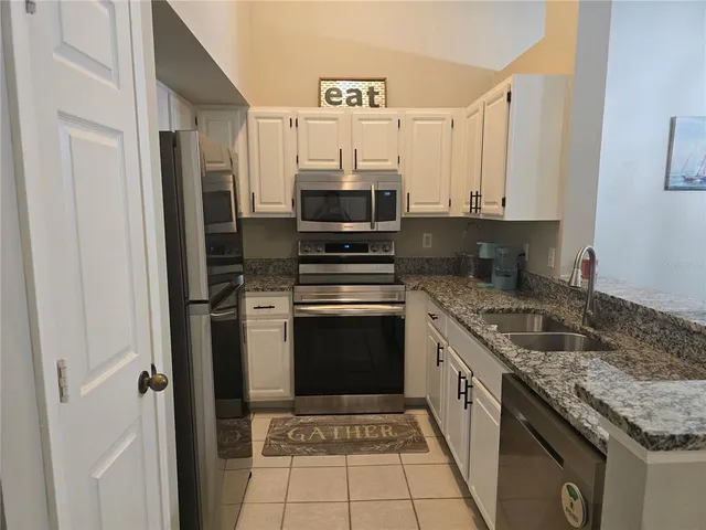 a kitchen with stainless steel appliances granite countertop a stove and a refrigerator