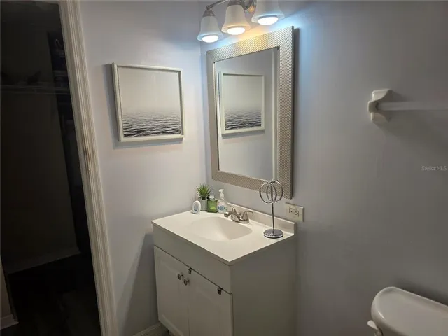 a bathroom with a sink toilet and mirror