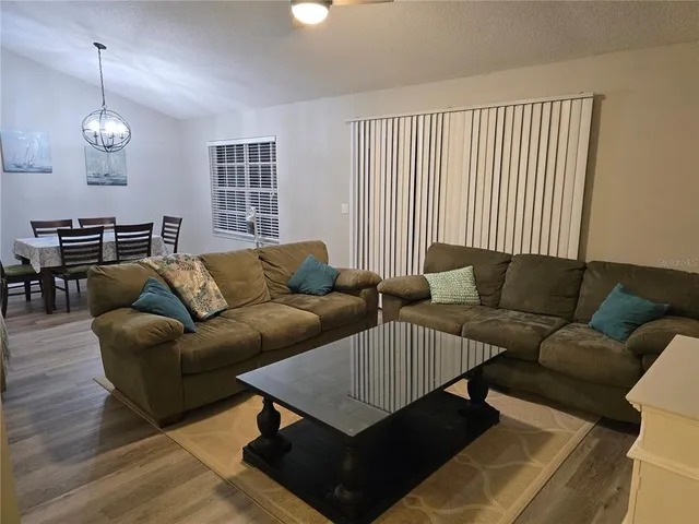 a living room with furniture ceiling fan and a window
