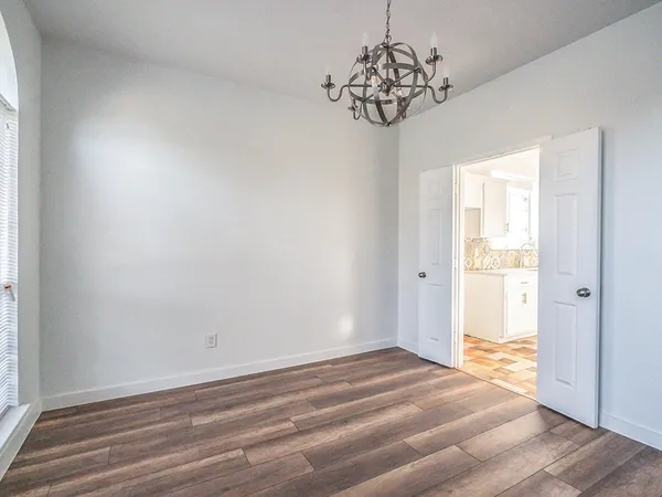 a view of a livingroom with wooden floor and a window