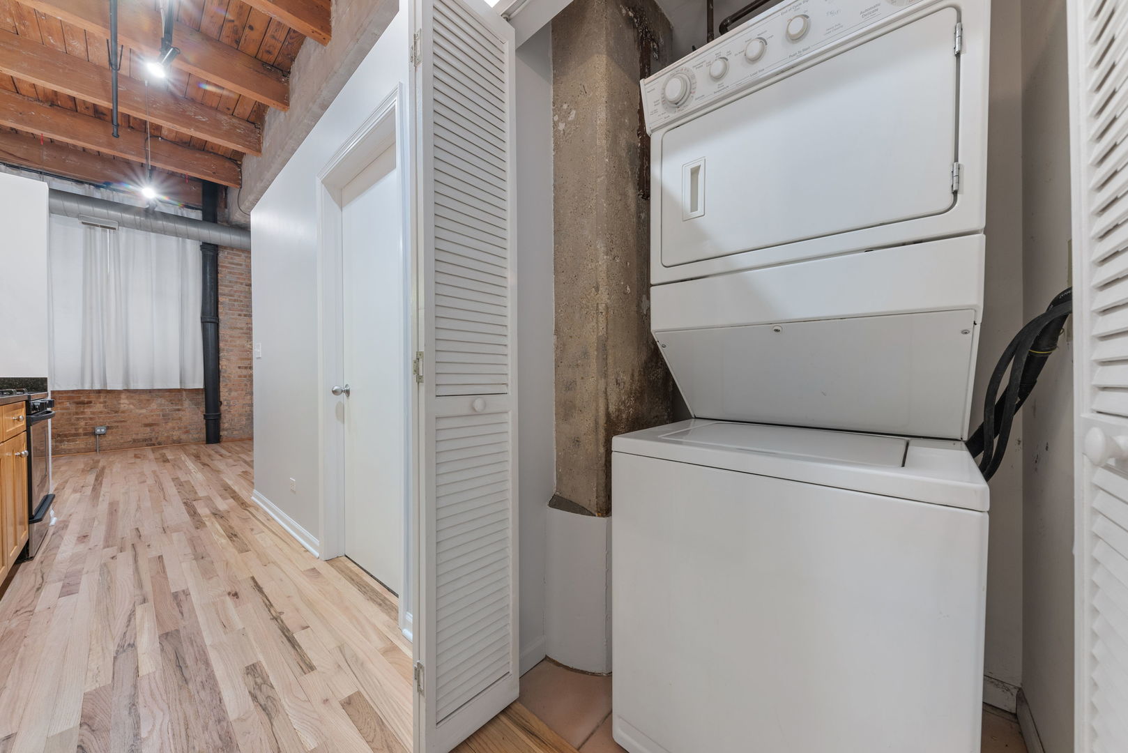 215 North Aberdeen Street, Unit 202B Chicago, IL 60607 - Photo 13 of 16 a view of washer and dryer with wooden floor