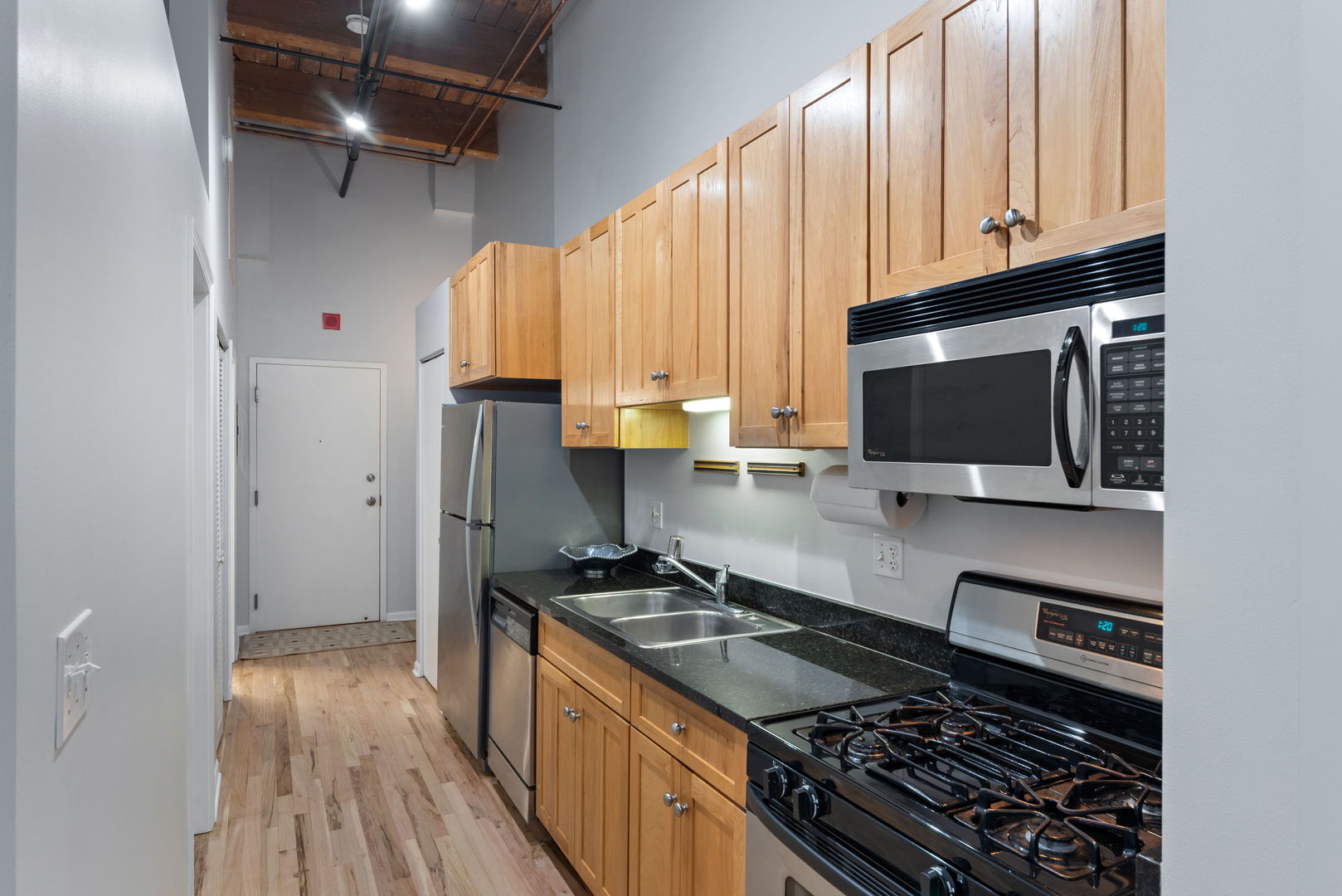 215 North Aberdeen Street, Unit 202B Chicago, IL 60607 - Photo 8 of 16 a kitchen with stainless steel appliances granite countertop a stove and a microwave
