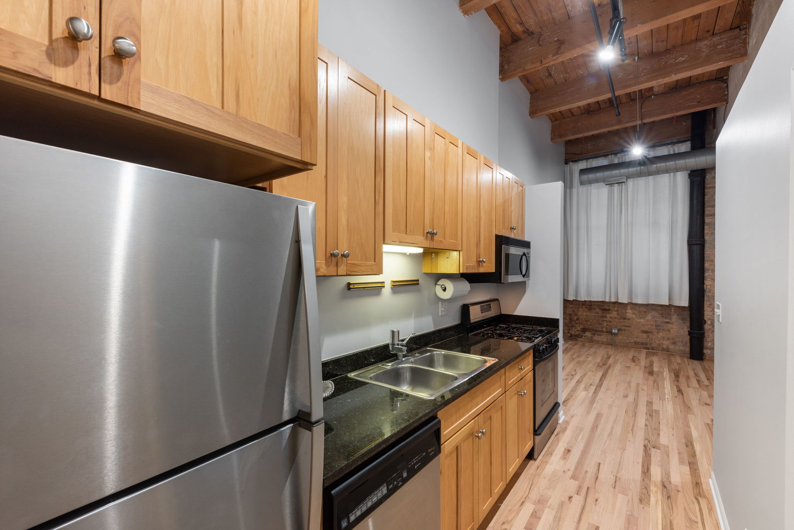 215 North Aberdeen Street, Unit 202B Chicago, IL 60607 - Photo 10 of 16 a kitchen with granite countertop a refrigerator stove and sink