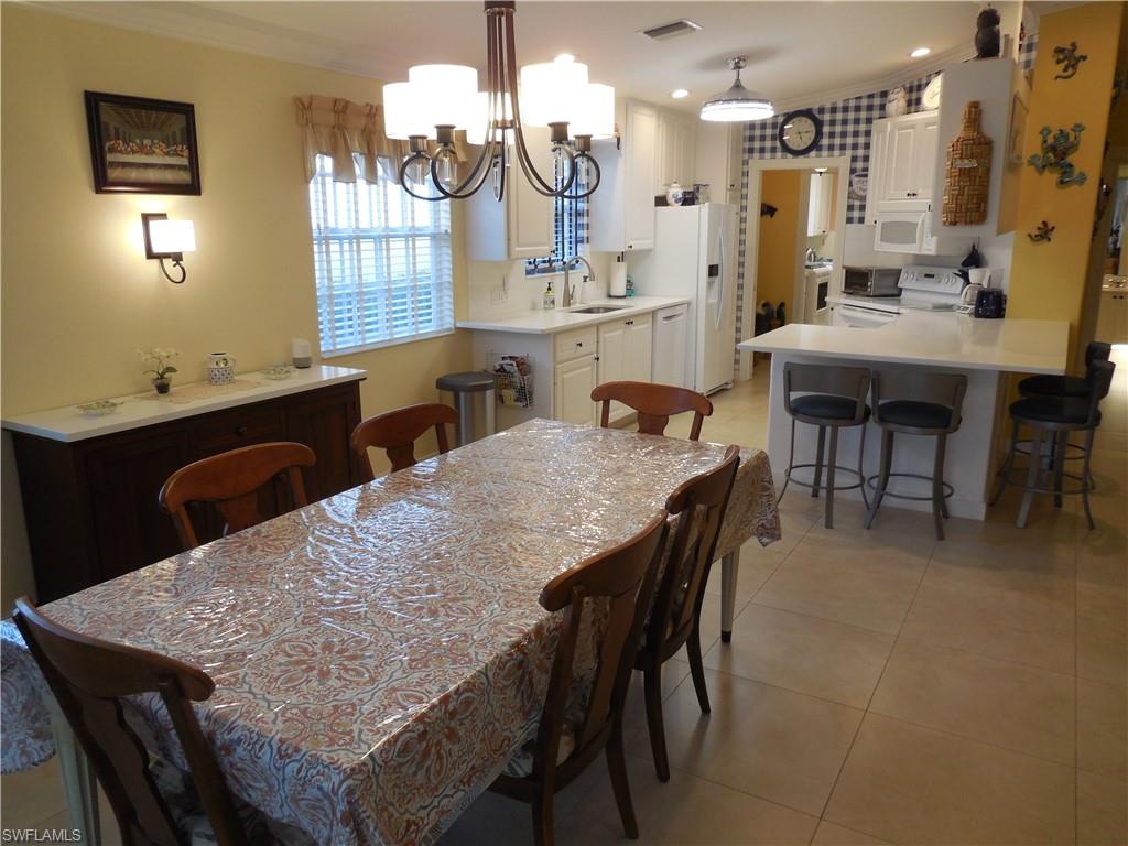 3703 Exuma Way Naples, FL 34119 - Photo 19 of 47 a dining table with chairs and window