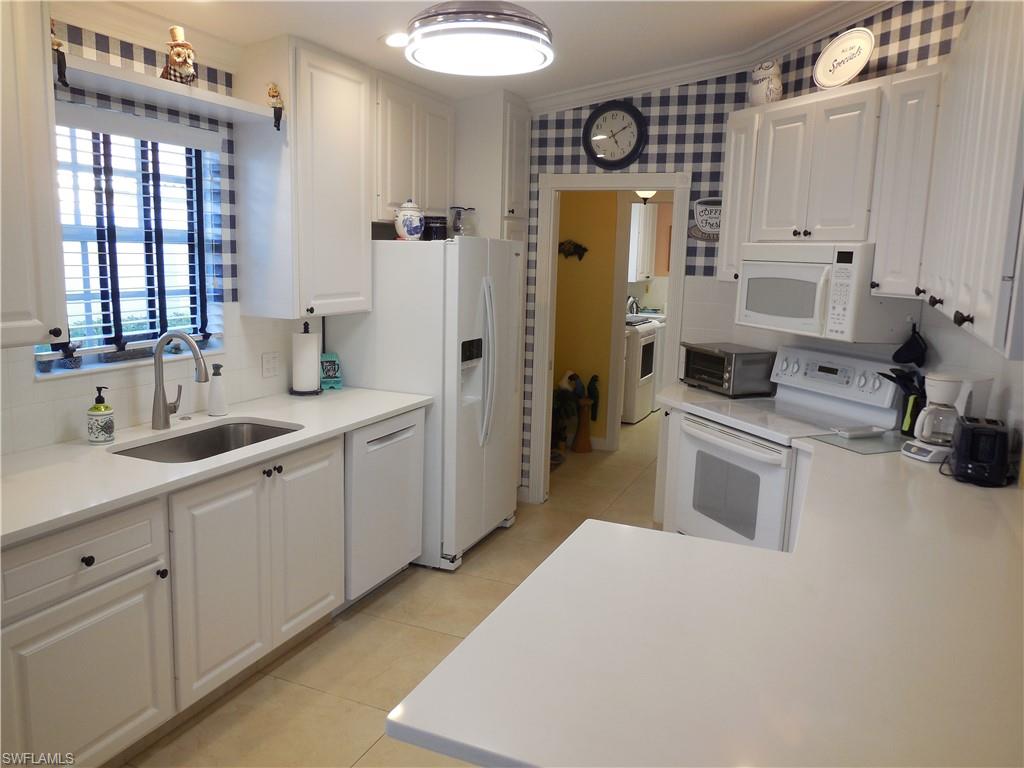 3703 Exuma Way Naples, FL 34119 - Photo 5 of 47 a large white kitchen with cabinets and white appliances