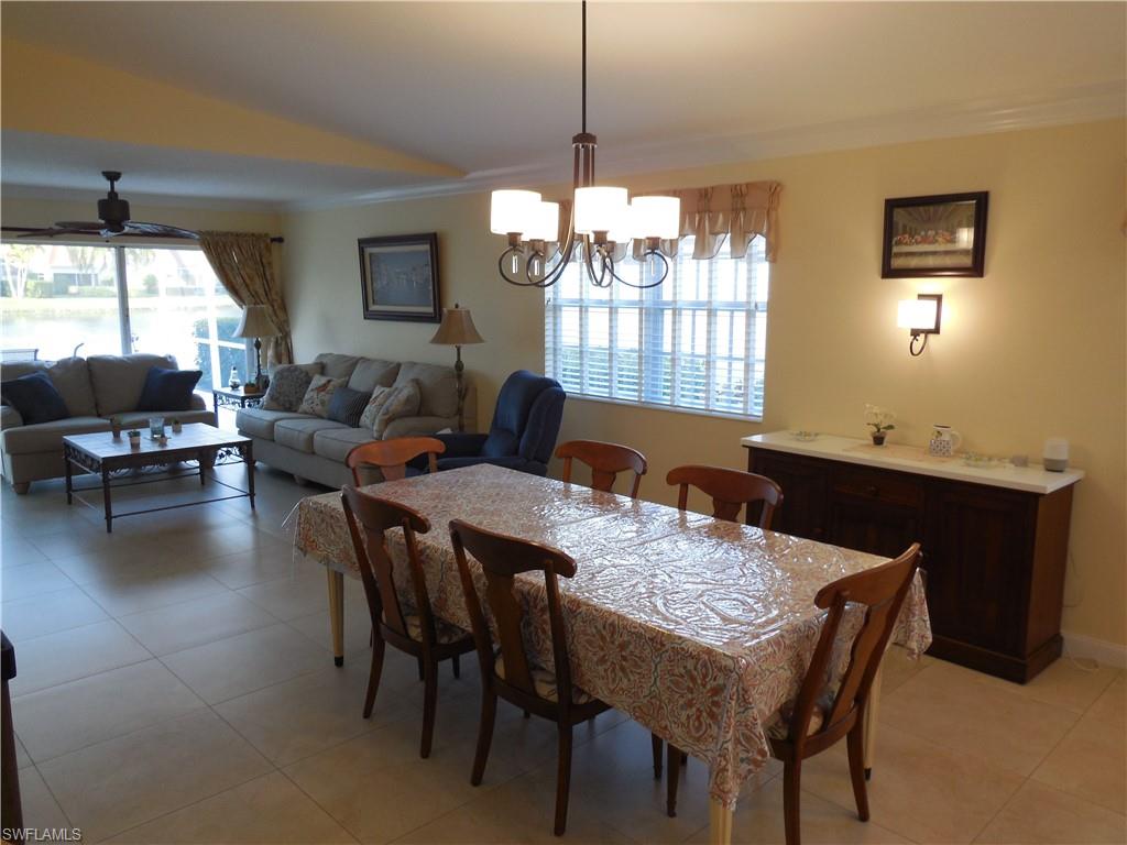3703 Exuma Way Naples, FL 34119 - Photo 9 of 47 a view of a dining room with furniture window and wooden floor