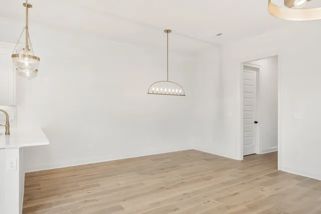 a view of a room with wooden floor a ceiling fan and window