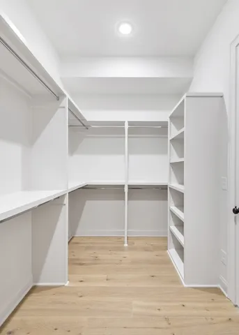 a view of walk in closet with empty racks