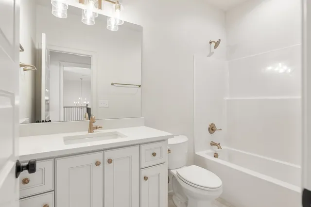 a bathroom with a sink a toilet a mirror a vanity and shower