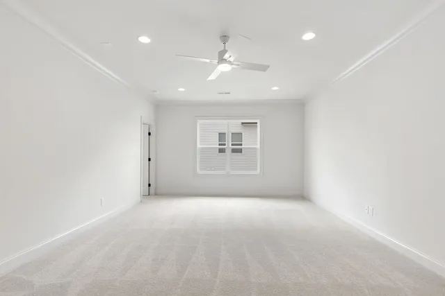 en empty room with windows and ceiling fan