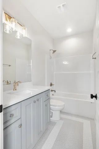 a bathroom with a toilet a bath tub a sink and mirror
