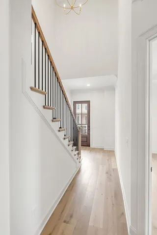 a view of a hallway with wooden floor and staircase