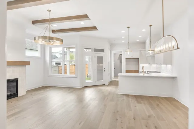 a view of a kitchen with granite countertop wooden floor stainless steel appliances and a chandelier