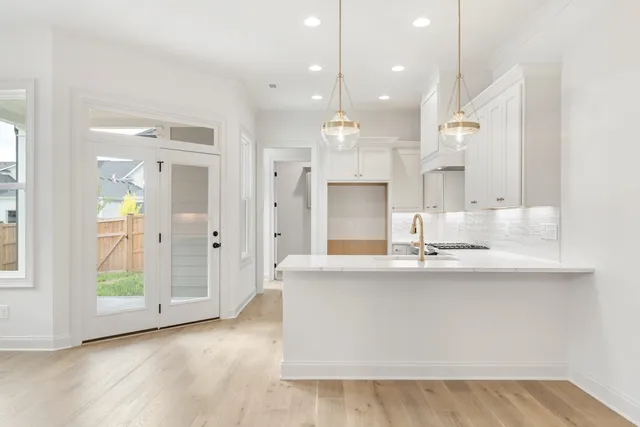 a large kitchen with granite countertop a sink and a refrigerator