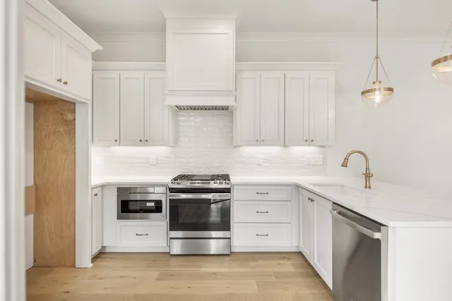 a kitchen with stainless steel appliances a stove a sink and a refrigerator