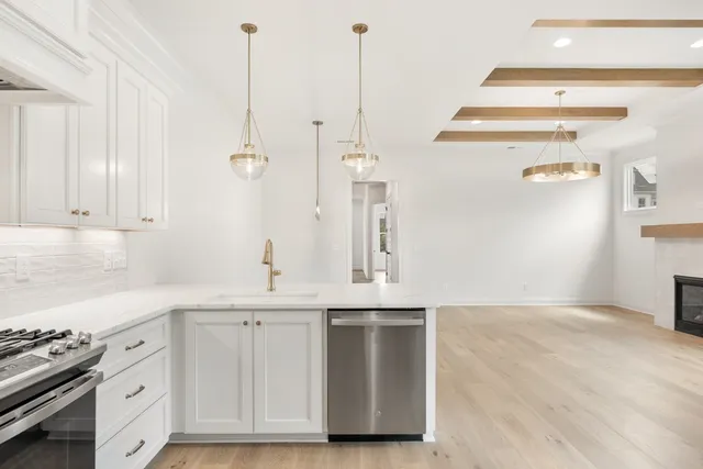 a kitchen with granite countertop a sink cabinets and stainless steel appliances