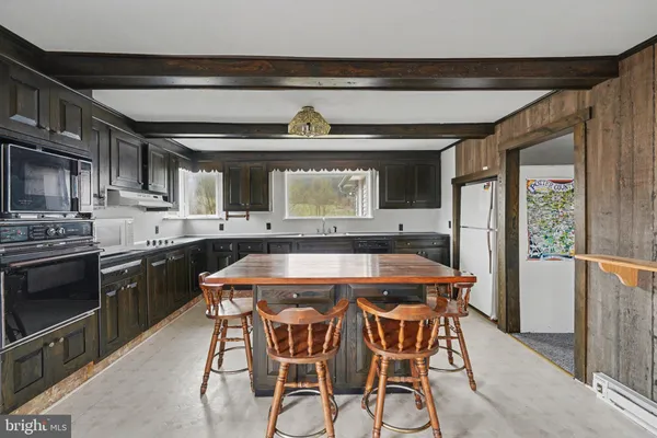 a kitchen with a table chairs sink and cabinets