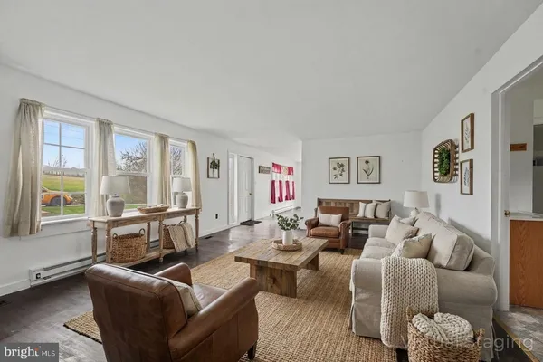 a living room with furniture wooden floor and a large window
