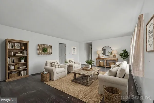 a living room with furniture a rug and a wall painting